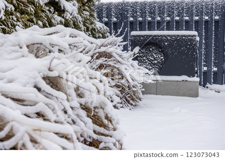 Outdoor heat pump unit covered in snow, providing energy-efficient heating for a swimming pool in winter. Outdoor heat pump unit covered in snow, providing energy-efficient heating for a swimming pool in winter. 123073043