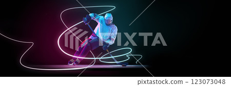 Ice hockey player in dynamic movement, aggressively maneuvering puck, glowing neon lines tracing speed and intensity against dark background. 123073048