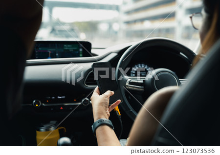 Woman using her cellphone while driving a car. 123073536