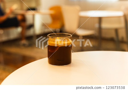 Iced coffee with slice of orange on a  table in cafe. 123073538