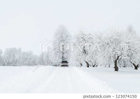 Rear view of the car on a snowy country road, rural winter landscape Rear view of the car on a snowy country road, rural winter landscape 123074150