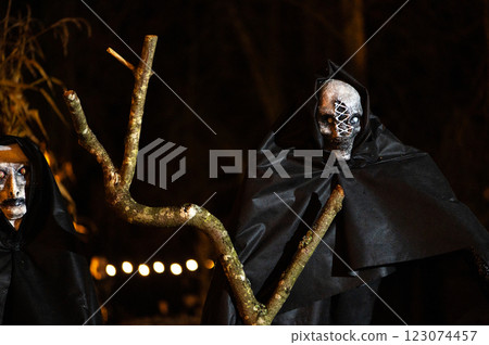 Scary Halloween witch with red eyes in a black cloak in a gloomy environment Scary Halloween witch with red eyes in a black cloak in a gloomy environment 123074457