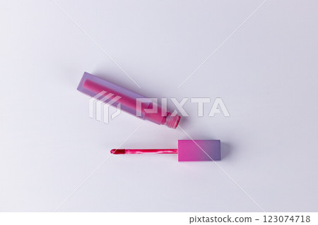 Vibrant Pink Lip Gloss with Applicator Wand on White Background for Beauty and Makeup Enthusiasts: A Perfect Addition to Your Cosmetic Collection 123074718