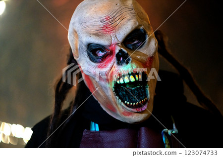 Close-up of monster face on a dark halloween horror night background Close-up of monster face on a dark halloween horror night background 123074733