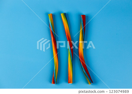 Vibrant Twisted Candy Straws Against a Light Blue Background, Offering a Playful and Colorful Treat for All Ages, Perfect for Parties and Sweet Celebrations Vibrant Twisted Candy Straws Against a Light Blue Background, Offering a Playful and Colorful Treat for All Ages, Perfect for Parties and Sweet Celebrations 123074989
