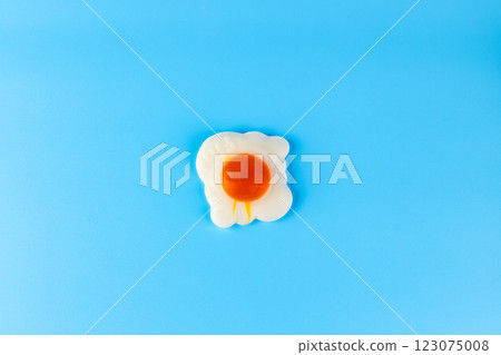 A Colorful Representation of a Fried Egg on a Vibrant Blue Background Perfect for Kitchen Decor and Food-themed Designs 123075008