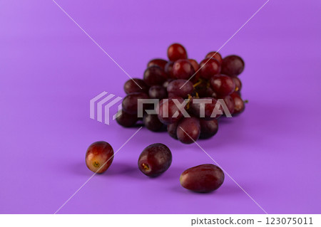 A Vibrant Display of Fresh Grapes on a Bright Purple Background, Capturing the Essence of Healthy Living and Nature's Sweet Bounty in a Beautifully Styled Arrangement 123075011