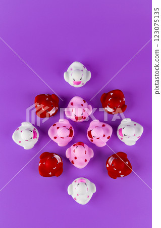 A Colorful Arrangement of Playful Rubber Ducks Featuring Vibrant Colors and Heart Patterns on a Purple Background 123075135