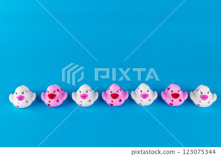 Colorful Rubber Ducks in a Row on a Bright Blue Background Perfect for Kid's Bathroom Decor or Toy Collection Featuring Adorable Heart Designs and Smiling Faces Colorful Rubber Ducks in a Row on a Bright Blue Background Perfect for Kid's Bathroom Decor or Toy Collection Featuring Adorable Heart Designs and Smiling Faces 123075344