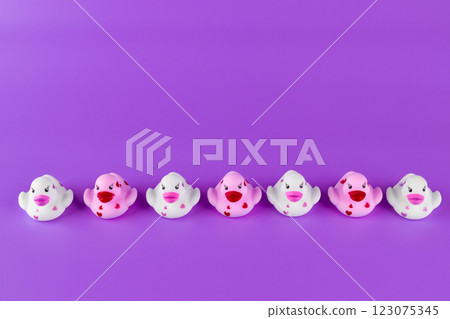Adorable Collection of Colorful Rubber Ducks in a Row Against a Vibrant Purple Background, Perfect for Playtime or Decorative Fun 123075345