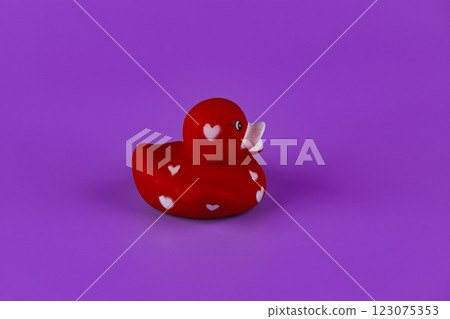 Charming Red Rubber Duck with Heart Patterns on a Vibrant Purple Background for an Adorable and Playful Bath Time Experience and Decorative Touch Charming Red Rubber Duck with Heart Patterns on a Vibrant Purple Background for an Adorable and Playful Bath Time Experience and Decorative Touch 123075353