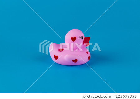 Charming Pink Rubber Duck with Heart Decorations Displaying a Playful and Cute Design Against a Bright Blue Background Perfect for Kids or Collectors Charming Pink Rubber Duck with Heart Decorations Displaying a Playful and Cute Design Against a Bright Blue Background Perfect for Kids or Collectors 123075355