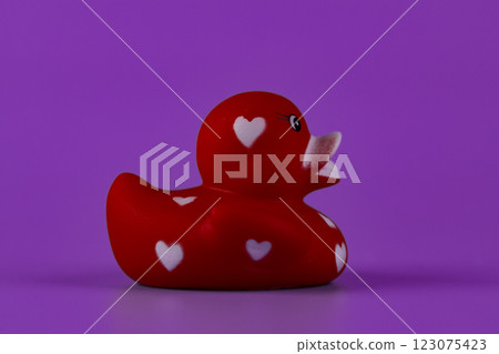 Charming Red Rubber Duck with Heart Patterns Captivatingly Posed Against a Bright Purple Background for a Playful and Whimsical Touch Perfect for Kids and Adults Alike Charming Red Rubber Duck with Heart Patterns Captivatingly Posed Against a Bright Purple Background for a Playful and Whimsical Touch Perfect for Kids and Adults Alike 123075423