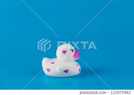 Adorable Rubber Duck with Heart Patterns on a Vibrant Blue Background: A Charming Addition to the Bathroom or Playroom Decor That Brings Joy and Fun to Any Setting 123075462