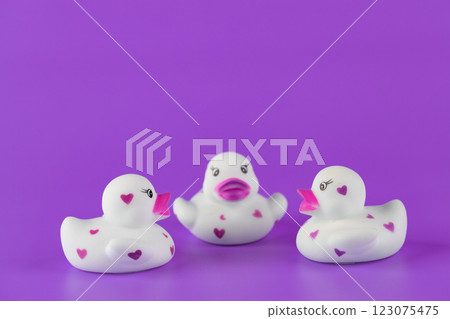 Adorable Collection of Three Cute Rubber Ducks Displaying Hearts Against a Vibrant Purple Background for a Fun and Playful Vibe Perfect for Children s Toys Adorable Collection of Three Cute Rubber Ducks Displaying Hearts Against a Vibrant Purple Background for a Fun and Playful Vibe Perfect for Children s Toys 123075475