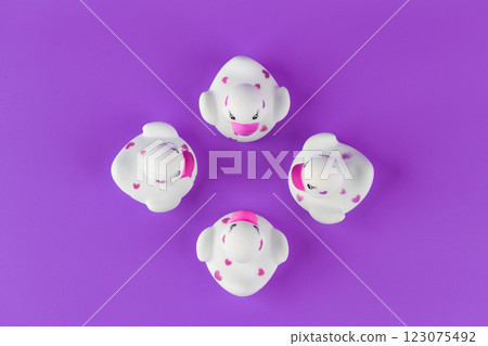 A Charming Display of Four Unique Rubber Ducks with Pink Hearts on a Vibrant Purple Background Creating a Fun and Playful Composition for All Ages 123075492