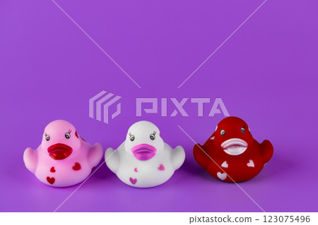Colorful and Adorable Rubber Duck Collection: Pink, White, and Red Ducks with Hearts, Perfect for Playtime and Decoration in Bright Purple Background 123075496