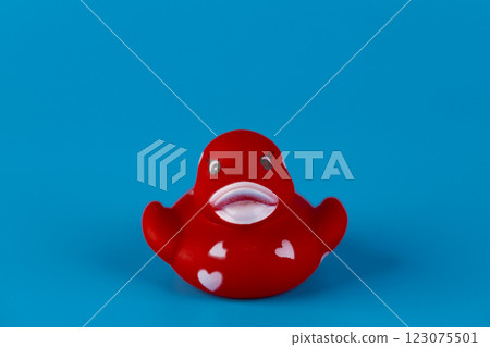 Adorable Red Rubber Duck with Love Hearts on Its Body Set Against a Bright Blue Background for Eye-Catching and Playful Aesthetic Adorable Red Rubber Duck with Love Hearts on Its Body Set Against a Bright Blue Background for Eye-Catching and Playful Aesthetic 123075501