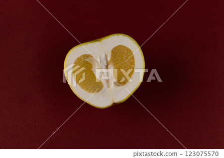 A Beautiful Slice of Bright Yellow Citrus Fruit Revealed Against a Deep Red Backdrop, Showcasing its Juicy Interior and Vibrant Colors for Culinary Inspiration and Fresh Flavor A Beautiful Slice of Bright Yellow Citrus Fruit Revealed Against a Deep Red Backdrop, Showcasing its Juicy Interior and Vibrant Colors for Culinary Inspiration and Fresh Flavor 123075570