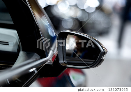 Side rear-view mirror on a modern car on blurred traffic background 123075935