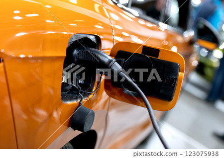 Closeup of power supply plugged into an modern electric car. Electric or EV car charging station. 123075938