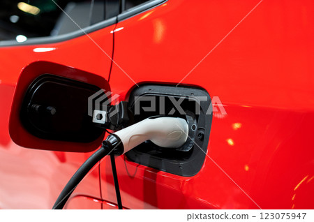 Closeup of power supply plugged into an modern electric car. Electric or EV car charging station. 123075947