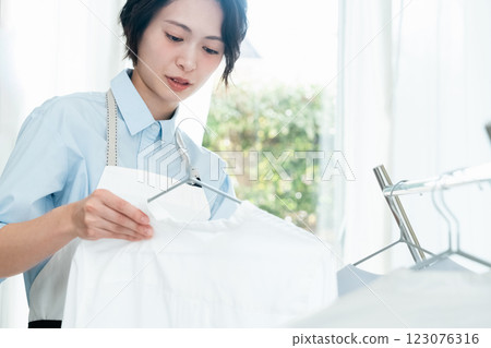 一個女人在房間裡晾衣服 一個女人在房間裡晾衣服 123076316