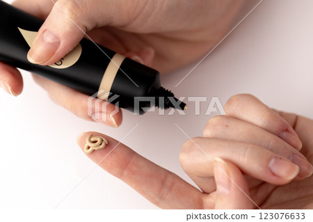 Capturing the Perfect Application of Foundation: A Close-Up of Hand Dispensing a Creamy Cosmetic Product for Flawless Skin Coverage 123076633