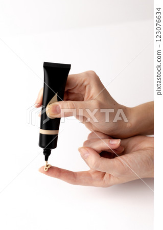 Elegant and Precise Application of Foundation in a Beauty Routine with a Sleek Black Tube, Highlighting the Art of Makeup for a Flawless Look and Enhanced Skin Tone Elegant and Precise Application of Foundation in a Beauty Routine with a Sleek Black Tube, Highlighting the Art of Makeup for a Flawless Look and Enhanced Skin Tone 123076634