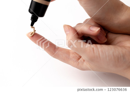 Applying Foundation on Finger: A Close-Up of Liquid Makeup Being Dispensed from a Bottle for Skincare and Beauty Application Techniques Applying Foundation on Finger: A Close-Up of Liquid Makeup Being Dispensed from a Bottle for Skincare and Beauty Application Techniques 123076636