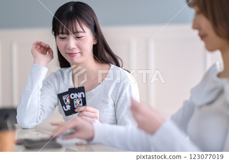 Two young women playing a card game 123077019