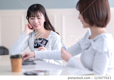Two young women playing a card game 123077021