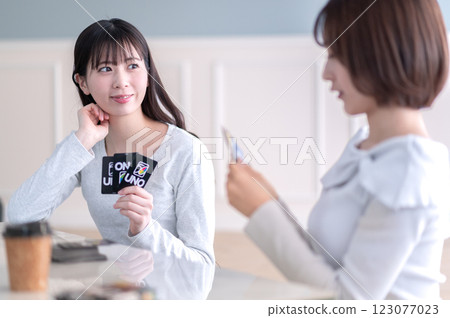 Two young women playing a card game Two young women playing a card game 123077023