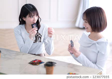 Two young women playing a card game 123077035