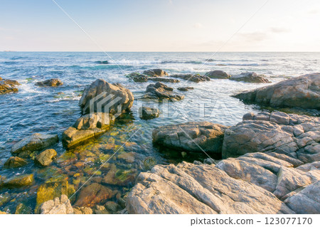 beautiful sunrise at the black sea. wide open horizon. rocky coast and clouds on the blue sky in morning light. summer vacations and weather change concept. holiday season beautiful sunrise at the black sea. wide open horizon. rocky coast and clouds on the blue sky in morning light. summer vacations and weather change concept. holiday season 123077170