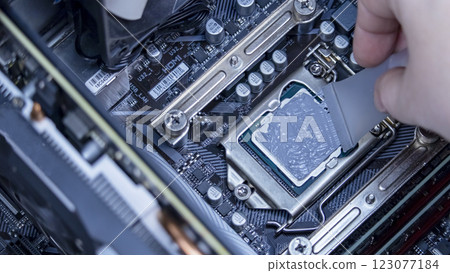 girl programmer apply thermal paste on the computer processor, macro photography girl programmer apply thermal paste on the computer processor, macro photography 123077184