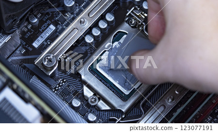 girl programmer apply thermal paste on the computer processor, macro photography girl programmer apply thermal paste on the computer processor, macro photography 123077191