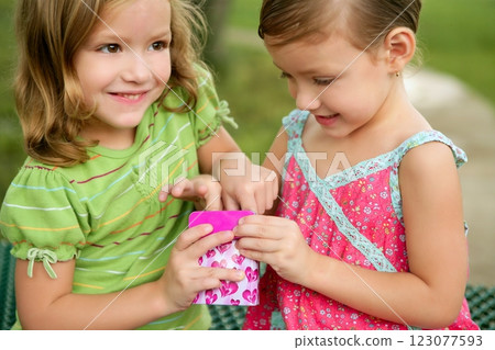Two little twin sisters playing with pink box Two little twin sisters playing with pink box 123077593