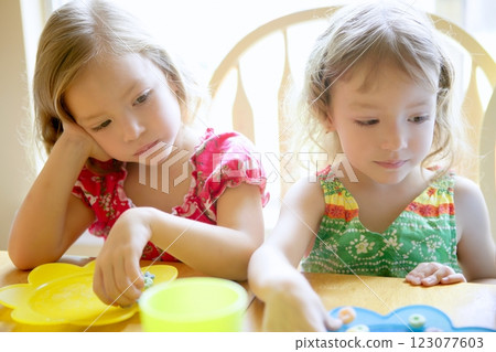 Two little sister girls eating together 123077603