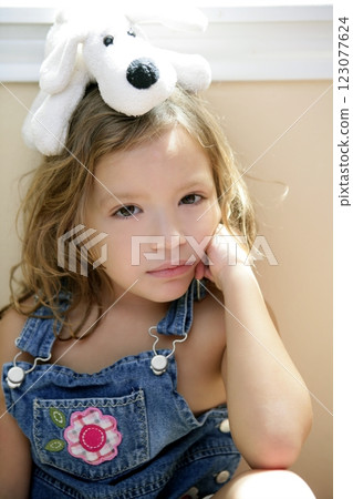 Happy toddler girl with toy dog over head 123077624