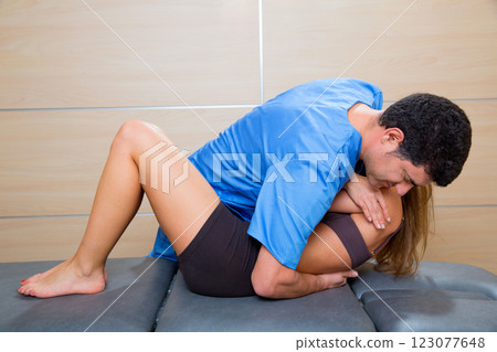Osteopathy dorsal spine manipulation doctor to woman Osteopathy dorsal spine manipulation doctor to woman 123077648