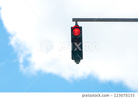 Red traffic light on blue cloudy sky background 123078155
