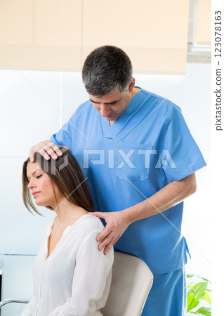 physiotherapist doing myofascial therapy on woman patient 123078163