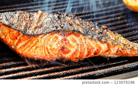 Delicious Grilled Salmon Fillet Cooking on the BBQ Grill Enhanced with Flavorful Seasoning 123078196