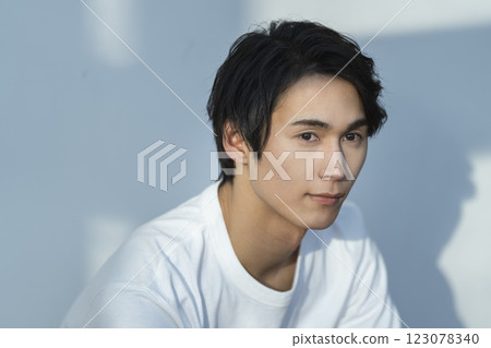 Men's beauty and skin care image: A young man wearing a white T-shirt 123078340