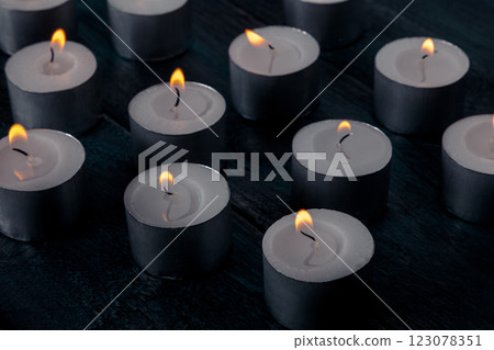 Tea light candles on a dark background, many lights in the dark Tea light candles on a dark background, many lights in the dark 123078351