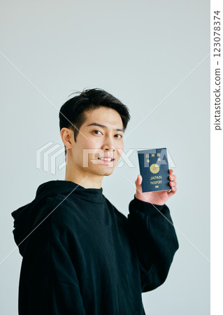A young man in his twenties holding a passport 123078374