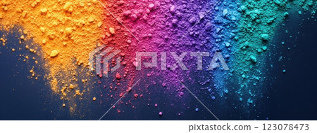 Gradient of scattered Holi powder in warm and cool tones transitioning from orange to blue on dark surface. 123078473