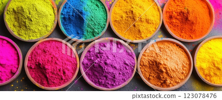 Wooden bowls filled with bright Holi powders in shades of purple, pink, blue, green, yellow, and orange. Top view. 123078476