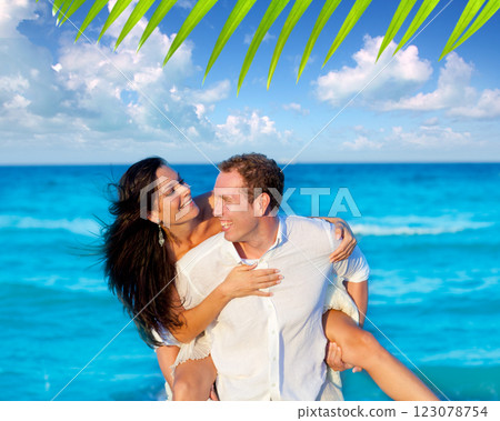 couple in love piggyback playing in beach 123078754